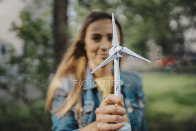 Молодая женщина держит модель ветряной турбины — стоковое фото