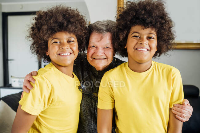 Nonna abbracciare due nipoti gemelli a casa — Foto stock