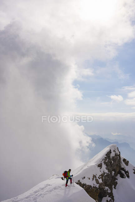 Randonneur marchant vers le sommet de montagne contre le ciel — Photo de stock