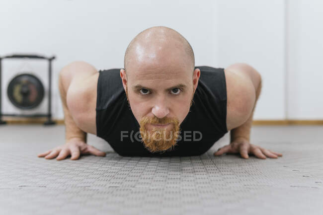 Entschlossener Mann übt Liegestütze am Boden im Fitnessraum — Stockfoto
