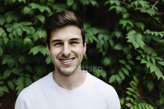 Усміхнений красивий чоловік перед деревом — стокове фото