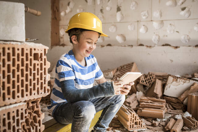 Усміхнений хлопчик з книгою, що сидить вдома під час реконструкції. — стокове фото