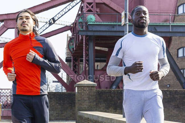 Men running together on sunny day — Stock Photo