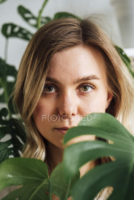 Красива жінка бачить через листя вдома — стокове фото