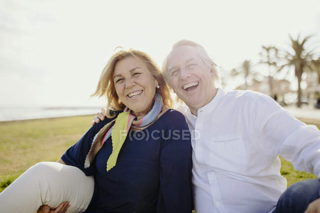 Felice uomo maturo seduto con la donna indossa sciarpa durante le vacanze — Foto stock