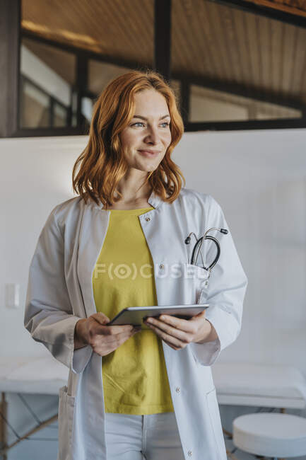 General practitioner with digital tablet standing at clinic — Stock Photo