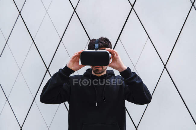 Uomo tenendo realtà virtuale auricolare da parete — Foto stock