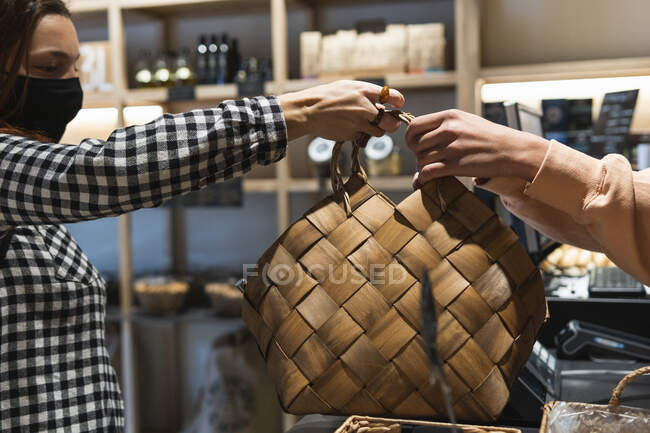 Жінка отримує сумку від власника в супермаркеті — стокове фото