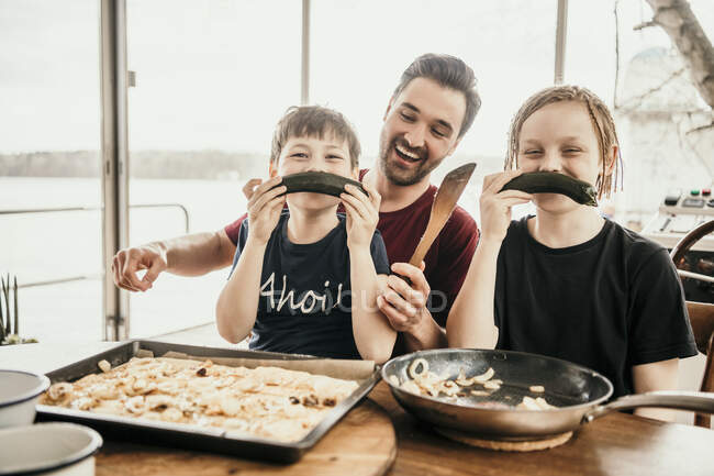 Verspielte Jungs basteln Schnurrbart mit Zucchini auf Hausboot — Stockfoto