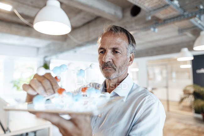Homme entrepreneur tenant modèle de molécule sur tablette numérique dans le bureau — Photo de stock