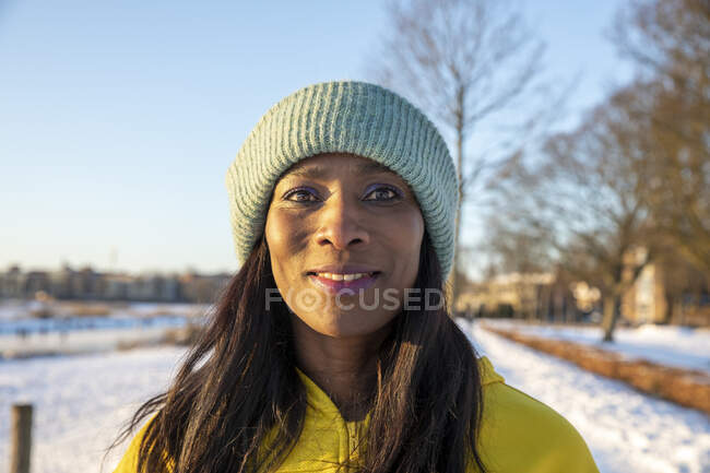 Schöne lächelnde Frau mit blauem Strickhut im Winter — Stockfoto