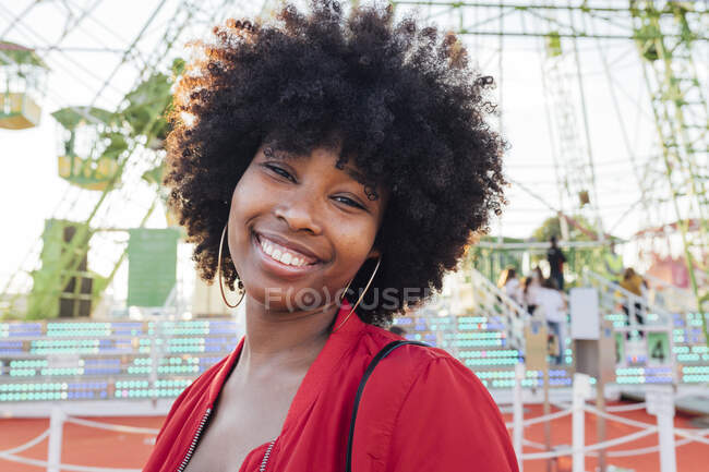 Молодая женщина улыбается в парке развлечений — стоковое фото
