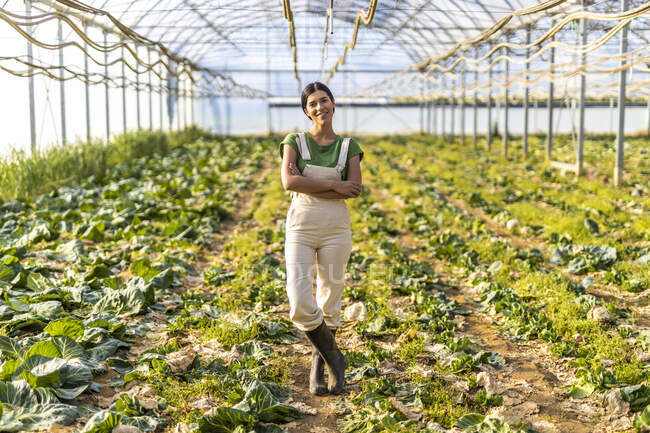 Agricoltrice in piedi con le braccia incrociate in serra — Foto stock