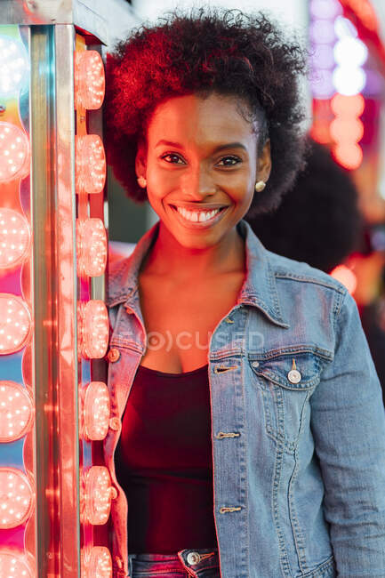 Felice donna africana di illuminazione attrezzature nel parco divertimenti — Foto stock