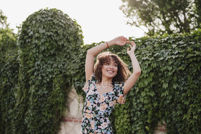 Felice giovane donna con le braccia alzate che balla in giardino — Foto stock