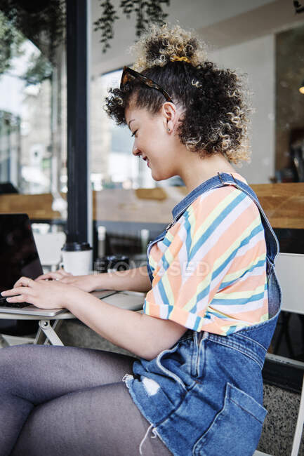 Mulher usando laptop no café calçada — Fotografia de Stock