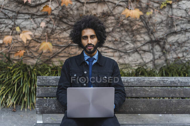Empresário com laptop sentado no banco — Fotografia de Stock