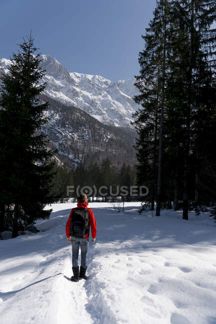 Hombre adulto medio con mochila senderismo en la nieve - foto de stock