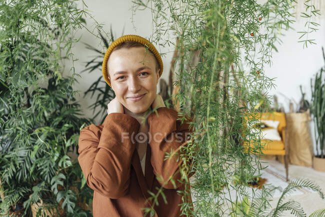 Donna d'affari sorridente che indossa cappello di maglia da piante a ufficio verde — Foto stock
