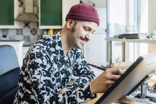 Lächelnder Mann mit Grafik-Tablet zu Hause — Stockfoto