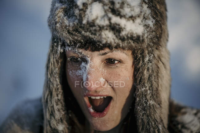 Surprised woman wearing hunters cap looking away with mouth open — Stock Photo