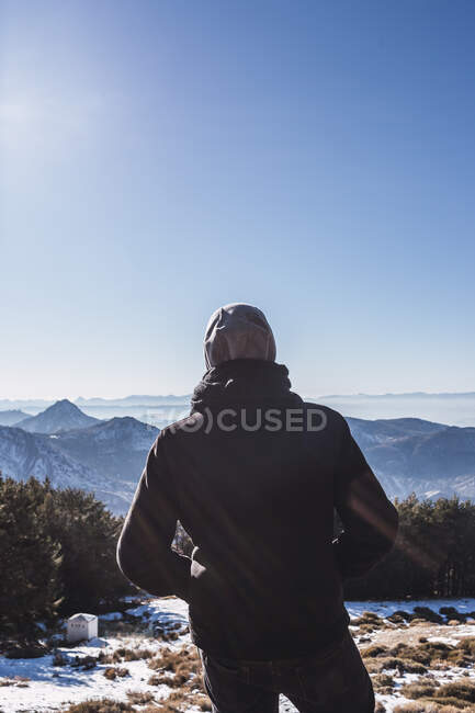Uomo guardando la vista mentre in piedi su un terreno innevato — Foto stock