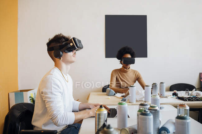 Young couple wearing virtual reality simulator while working in studio — Stock Photo