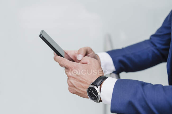 Businessman using mobile phone while leaning on railing — Stock Photo