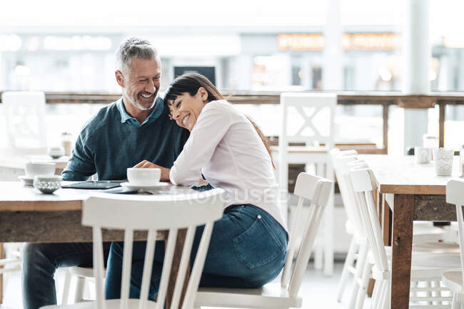 Feliz pareja de negocios sentados juntos en la cafetería - foto de stock
