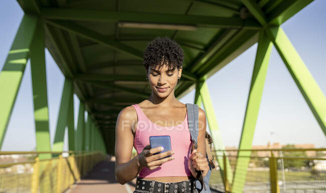 Woman using smart phone at bridge during sunny day — Stock Photo