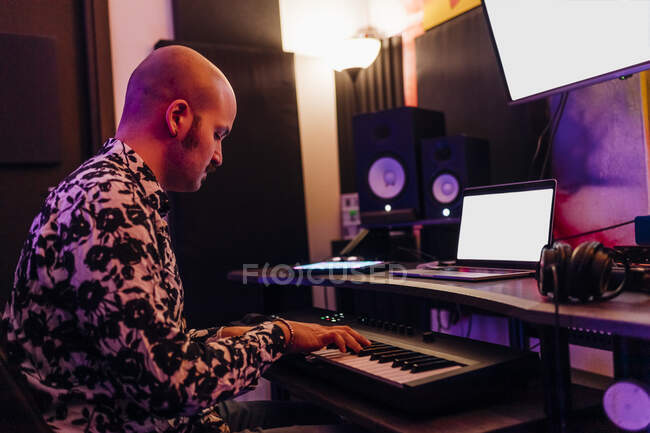 Homme jouant du piano tout en composant de la musique en studio — Photo de stock