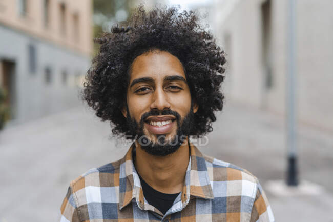 Joven con peinado afro sonriendo - foto de stock
