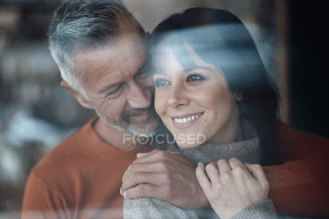 Uomo maturo con braccio intorno sulla donna sorridente al caffè — Foto stock