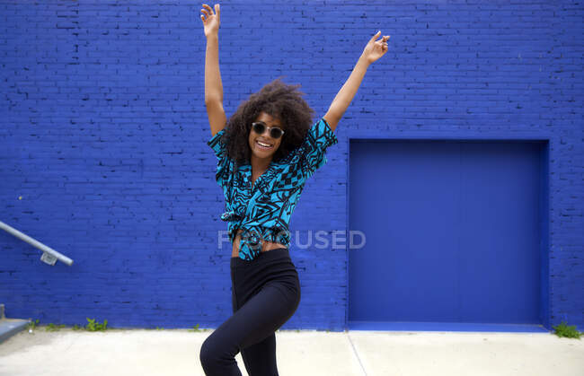 Giovane donna afro spensierata che balla con le mani alzate — Foto stock