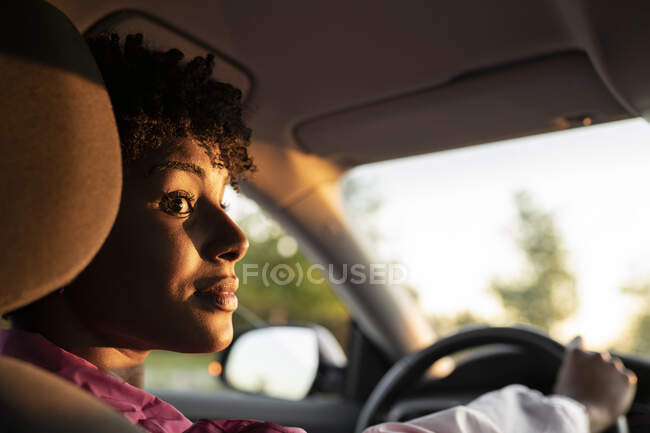 Giovane donna guardando lontano durante la guida di auto — Foto stock