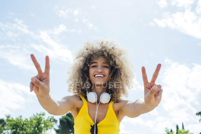 Joyeux jeune femme afro geste signe de paix sur une journée ensoleillée — Photo de stock