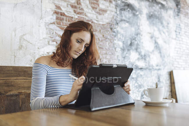 Businesswoman working on graphic tablet at cafe — Stock Photo