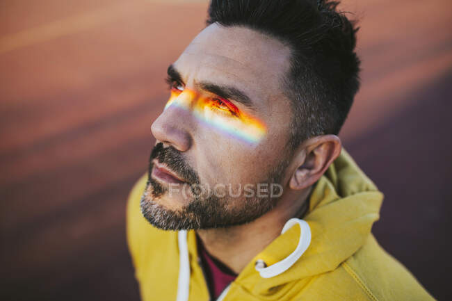 Hombre maduro con espectro en los ojos mientras mira hacia otro lado - foto de stock