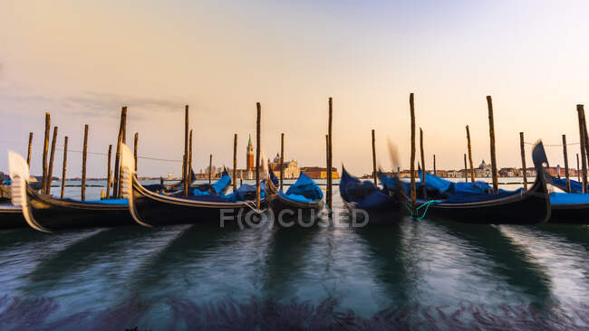 Italia, Veneto, Venezia, Fila di gondole ormeggiata in marina al tramonto — Foto stock