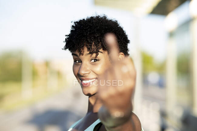 Молода жінка з середнім пальцем на вулиці. — стокове фото