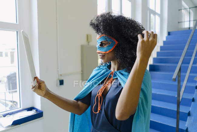 Mujer de negocios con máscara para los ojos y traje de tomar selfie a través de la tableta digital en la oficina - foto de stock
