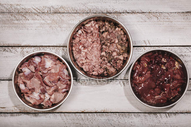 Trois bols d'aliments crus biologiquement appropriés (BARF) pour l'alimentation des chiens — Photo de stock