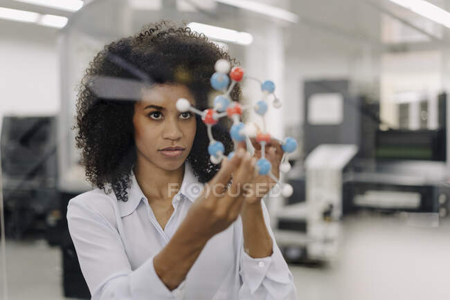 Entrepreneur féminin examinant la molécule dans l'industrie — Photo de stock