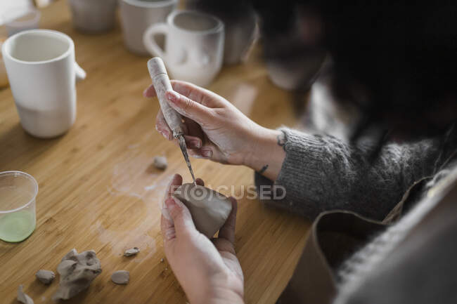 Жінка-художник з ручним інструментом і глиною на робочому місці — стокове фото