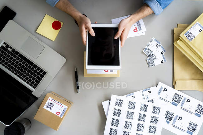 Geschäftsmann hält digitales Tablet über Box am Schreibtisch — Stockfoto