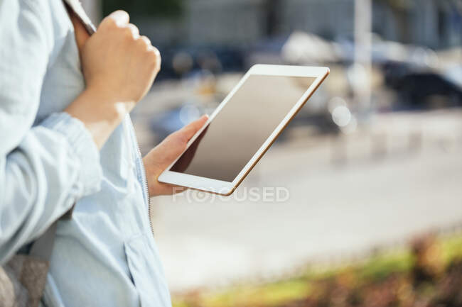 Femme adulte moyenne tenant tablette numérique à l'extérieur — Photo de stock