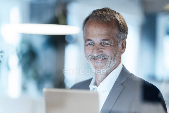 Uomo d'affari anziano che utilizza tablet digitale in ufficio — Foto stock