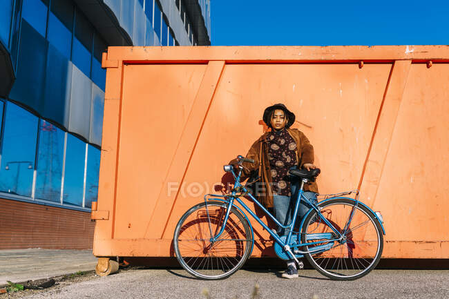 Giovane donna in piedi con la bicicletta sul sentiero durante la giornata di sole — Foto stock