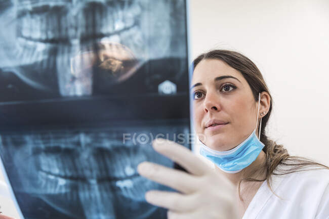 Odontoiatra che esamina i raggi X alla clinica medica — Foto stock
