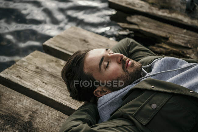 Mann schläft auf Holzsteg — Stockfoto